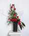 The tower of 12 roses dances with twigs of curly willow and textural greenery in a contemporary matte black ceramic vase. 