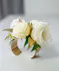 This corsage features elegant ivory blooms paired with greenery and accents of gold, all carefully designed on a metallic gold metal cuff.