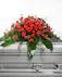 This classic half-couch spray of brilliant red carnations makes a striking and dignified statement during the final farewell service.