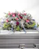 Like a heartfelt embrace, this beautiful casket spray delivers comfort and love in an extraordinary way with lavender and pink florals.