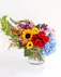 Flirty 30s boasts a beautiful blend of colorful roses, sunflowers, cremones, and hydrangeas, with each flower completing the other perfectly. 