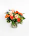 An orange tropical flower arrangement featuring birds of paradise, thistle, and roses. 