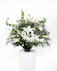 This arrangement offers sympathy ideal for the funeral service or home. The mix of lush greenery and delicate white blooms will bring peaceful wishes to the family.