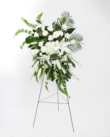 This display of white blooms is artfully arranged amongst lush greenery creating an outstanding way to honor the life of your loved one. 