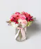 blush and ivory arrangement includes roses, gerbera daisies, lisianthus, hydrangea, and more in a timeless tall cylinder glass vase tied with a silk pink bow. 