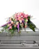 This pink and purple mixed casket spray lays beautifully atop of a casket like a handheld bouquet to pay tribute to your loved one.