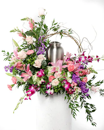 Express your deepest love with shades of pinks and purples. This cremation arrangement is a beautiful way to surround your loved ones urn.