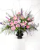 This perfect end piece for a funeral display features pink and purple blooms with lush greenery that symbolizes heartfelt sympathy.