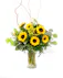 Bright petite sunflowers with cheerful yellow solidago and fresh greenery in a clear, hourglass-shaped glass vase. 