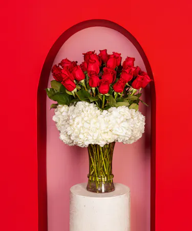 A modern twist on this bouquet of 36 long stem roses when we accent them with heavenly hydrangea and hypericum berries and arrange them in a bubble bowl. 