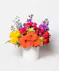 This colorful array of roses, gerbera daisies, delphinium, spray roses and more is sure to bring a smile to anyone's face.