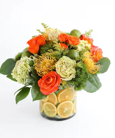 This arrangement represents our lovely sunshine state with fresh oranges, limes, yellow pin cushion protea, green tea roses, and other vibrant florals.