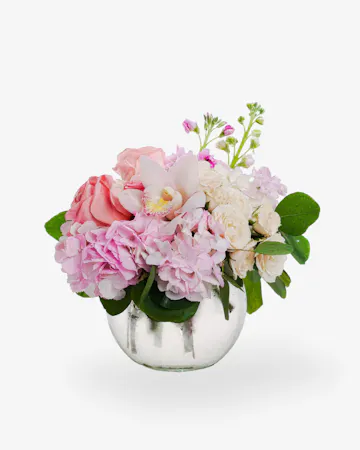 Beautiful cybidium orchids, roses, stock, hydrangea and more are elegantly designed in a clear glass bubble bowl vase